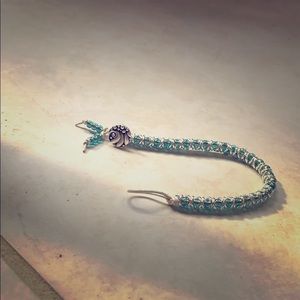 A handcrafted blue and silver button up bracelet